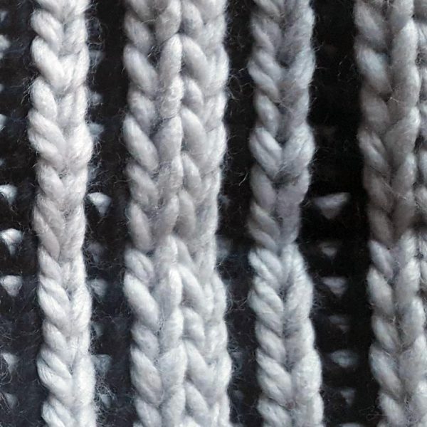 detalle tejido del gorro de punto rayas grises y negras con pompon